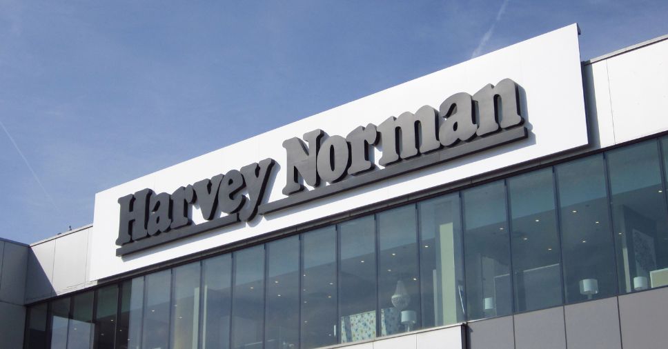 Letreiro em relevo destaca a marca na fachada com letra caixa de um prédio comercial.